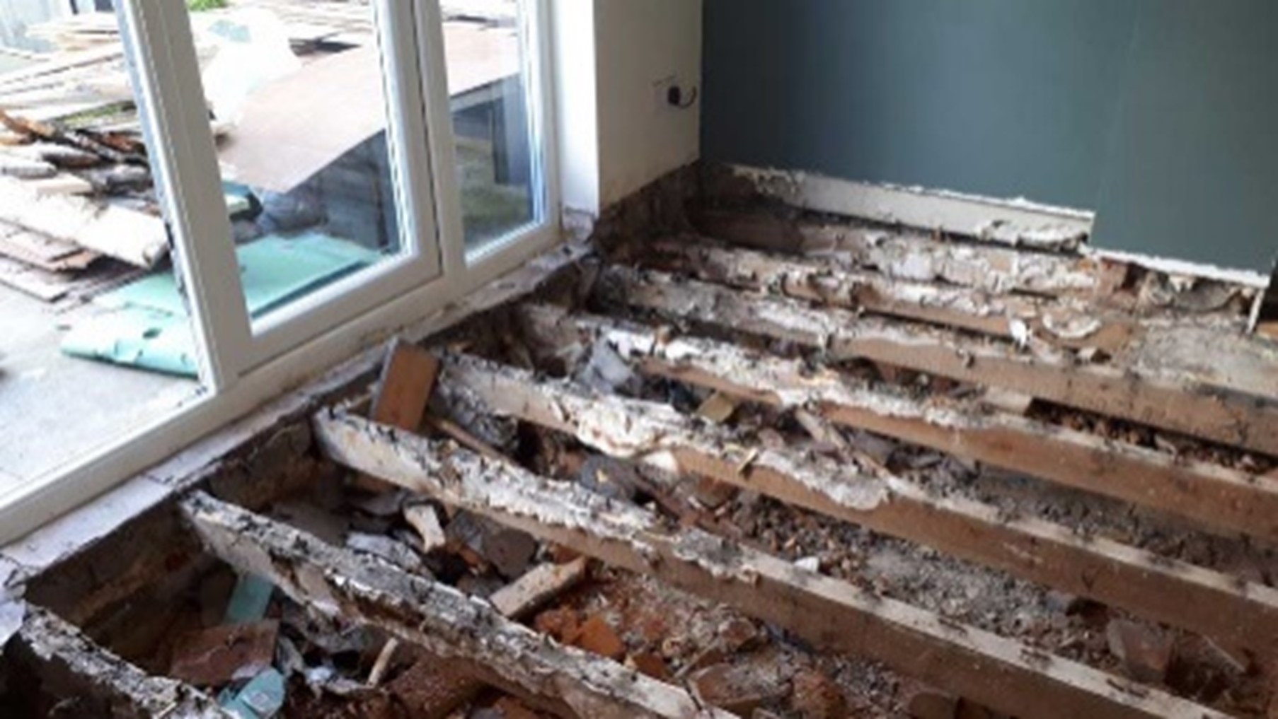 Exposed and badly rotted floor joists being replaced during timber treatment