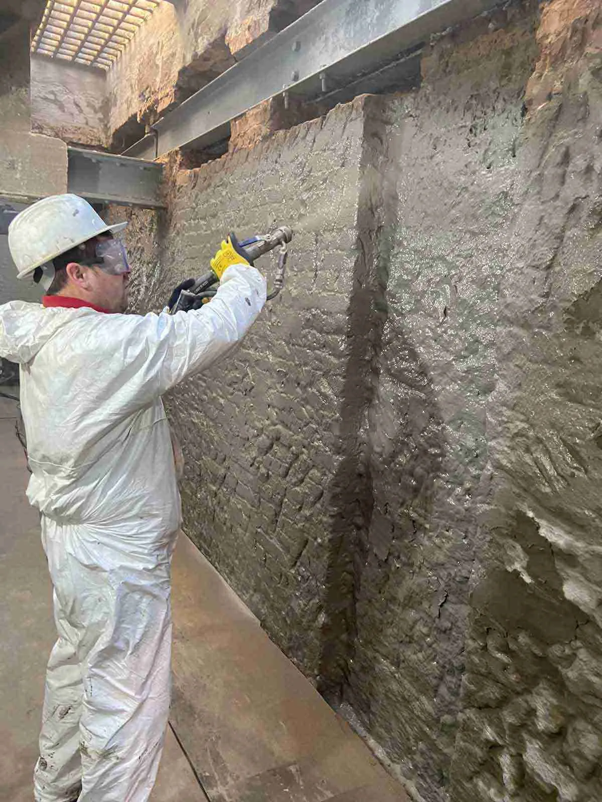 Specialist applying cementitious tanking slurry to a basement wall